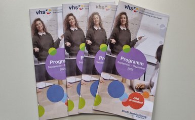 vier Programmhefte liegen nebeneinander